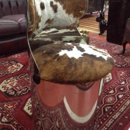 Poltroncina in acciaio tonda con seduta in pelle di mucca, design originale.