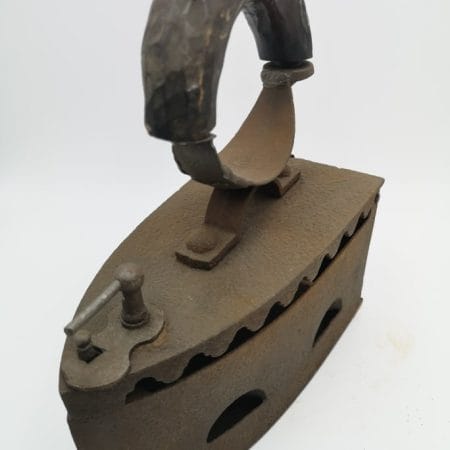 Vecchio ferro da stiro a legna in ghisa con manico in legno curvo