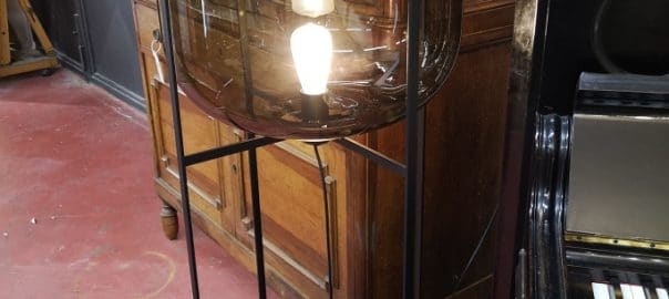 Lampada in vetro di design modello Oda, con paralume grigio fumé e struttura nera.