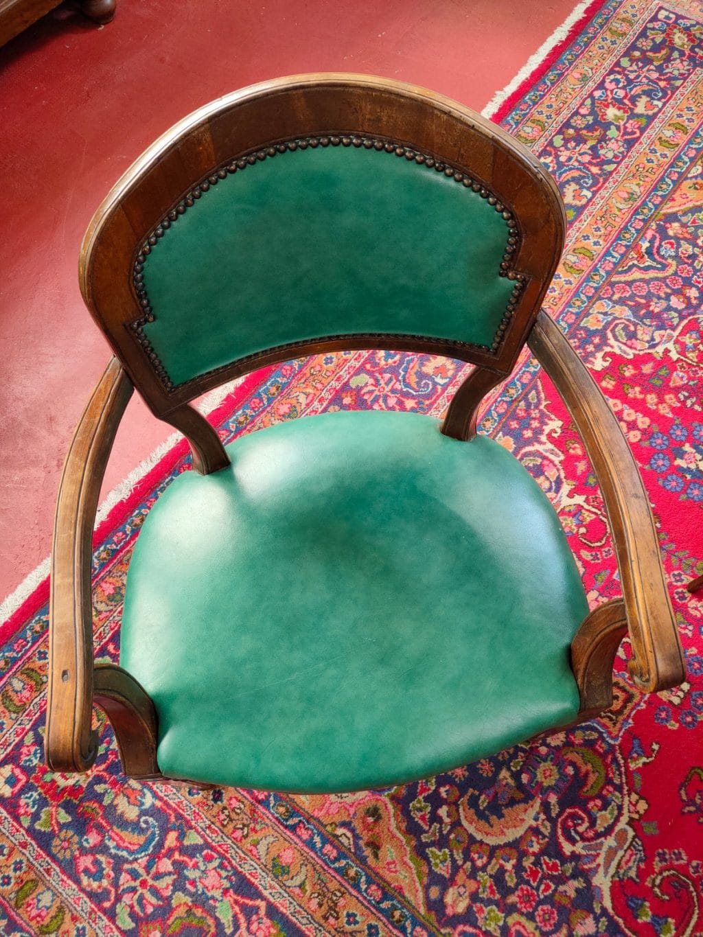 Storica poltroncina del 700 in legno di noce con rivestimento in skai verde.