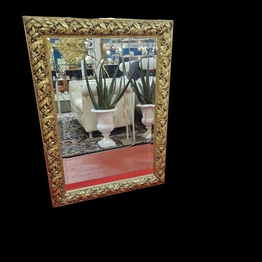 Specchiera lavorata in legno dorato con cornice intagliata e specchio bisellato