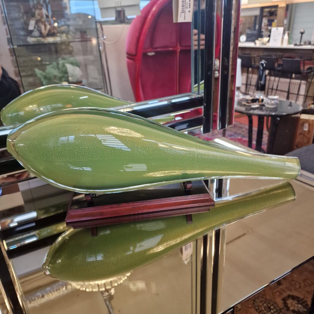 Scultura in vetro di Murano verde con scaglie d'oro raffigurante un elegante pesce su supporto in legno.