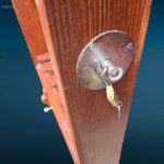 Fuciliera da muro in legno, con ganci robusti, fermo di sicurezza in acciaio e vano con serratura a chiave, perfetta per collezionisti e cacciatori.
