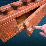 Fuciliera da muro in legno, con ganci robusti, fermo di sicurezza in acciaio e vano con serratura a chiave, perfetta per collezionisti e cacciatori.