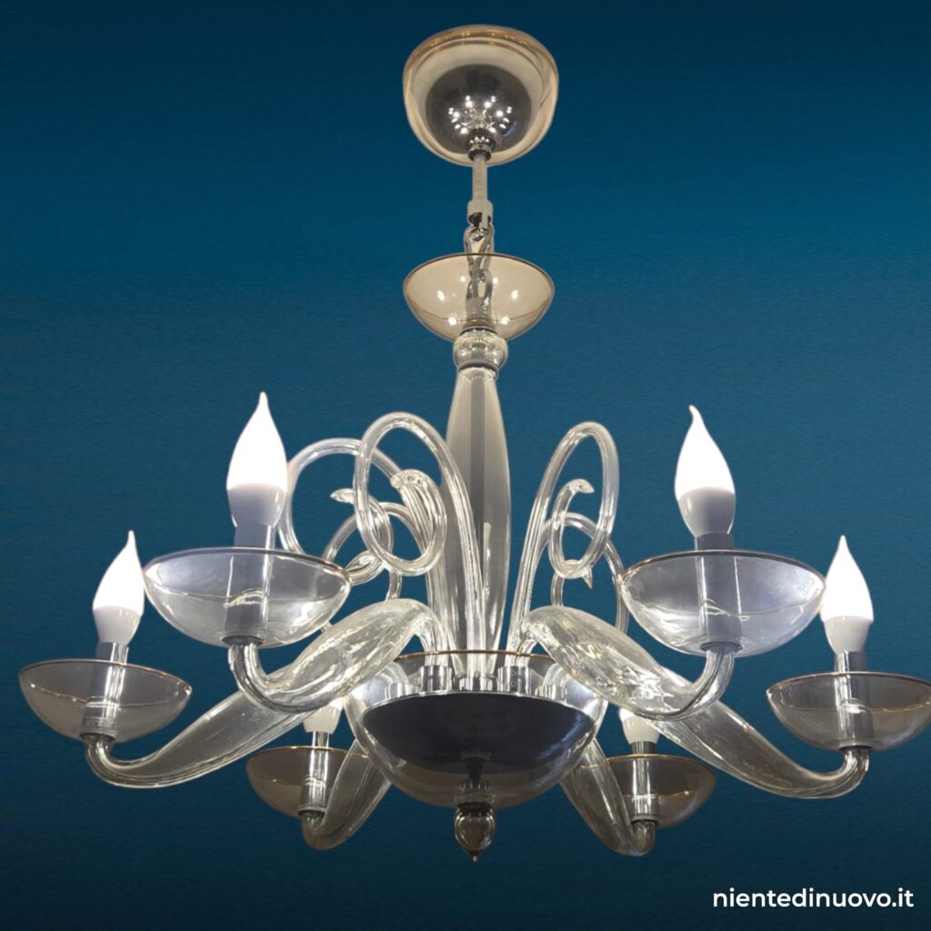 Lampadario in vetro soffiato chiaro con 6 luci, struttura raffinata e dettagli a spirale, perfetto per arredare ambienti eleganti con luce armoniosa e sofisticata.