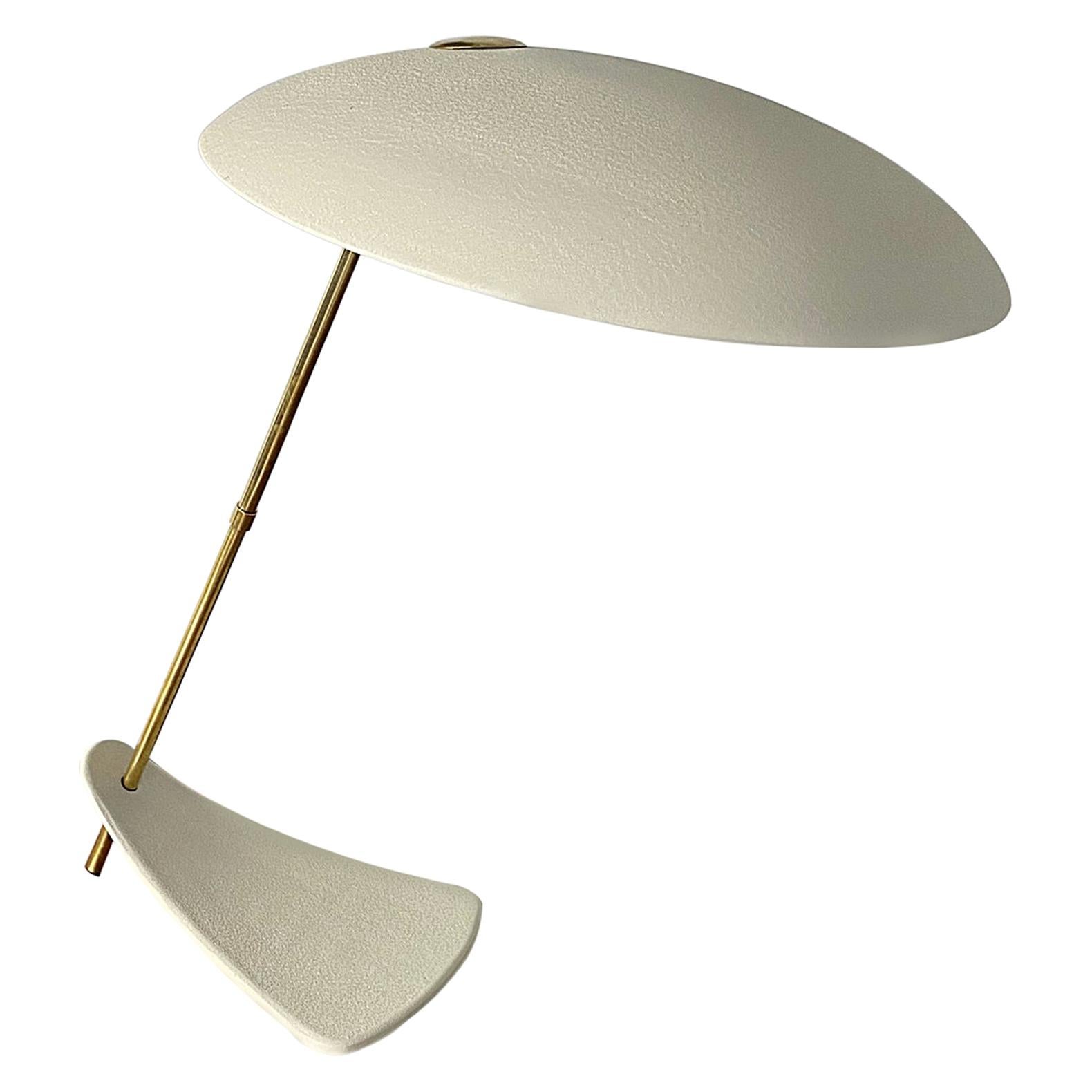 Lampada vintage anni ’50 con struttura dorata e paralume disco inclinato, tipica del design mid‑century.