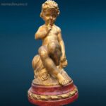 Puttino dorato in legno con base rossa laccata, oggetto decorativo pregiato