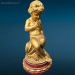 Puttino dorato in legno con base rossa laccata, oggetto decorativo pregiato
