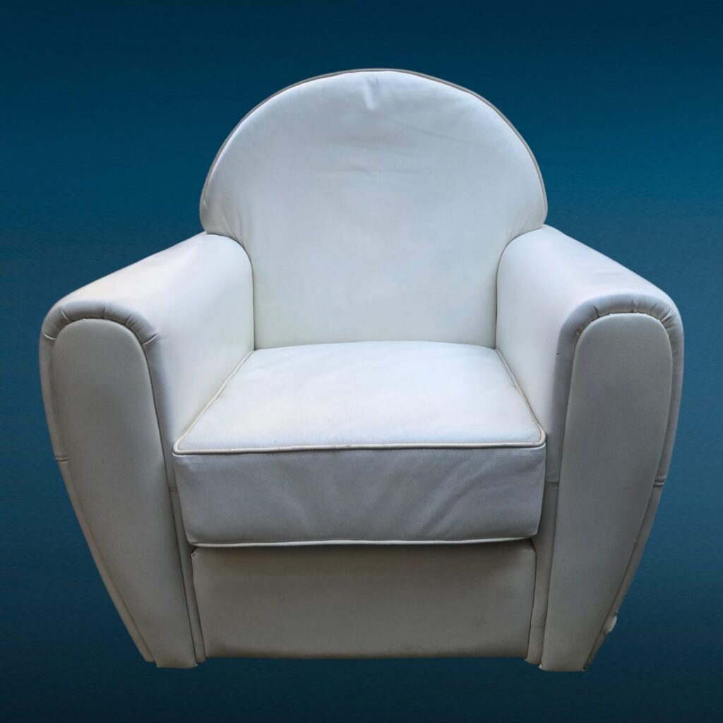 Poltrona in similpelle bianca con design iconico e segni del tempo