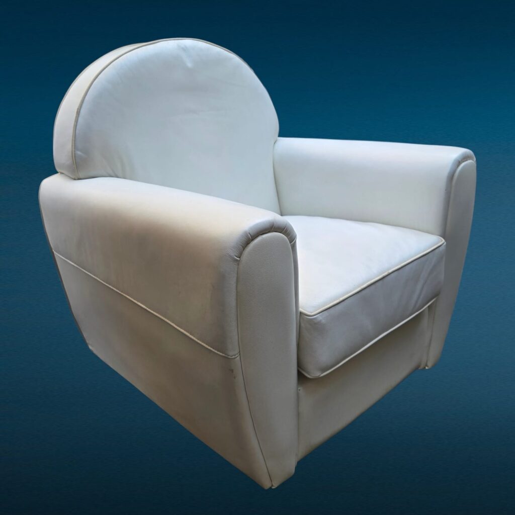 Poltrona in similpelle bianca con design iconico e segni del tempo