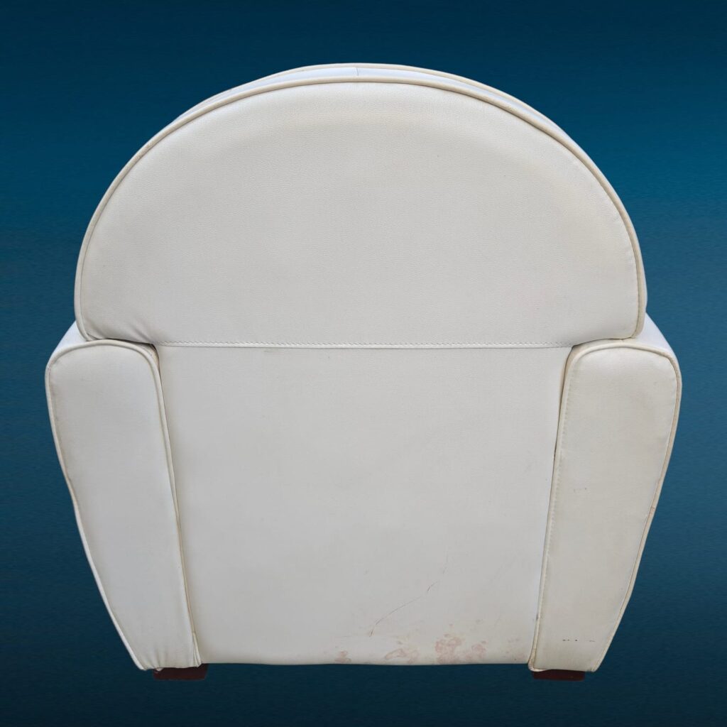 Poltrona in similpelle bianca con design iconico e segni del tempo