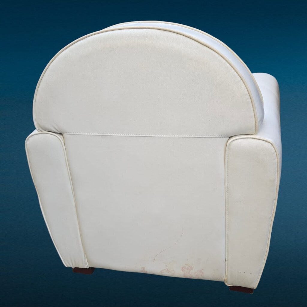 Poltrona in similpelle bianca con design iconico e segni del tempo