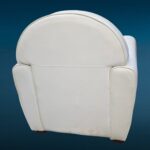 Poltrona in similpelle bianca con design iconico e segni del tempo