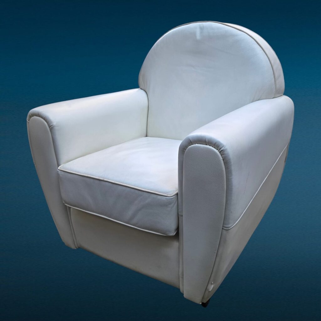 Poltrona in similpelle bianca con design iconico e segni del tempo