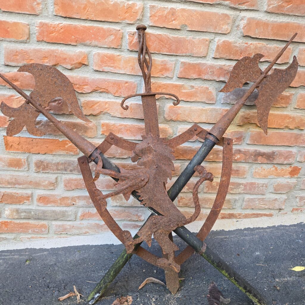 Scudo decorativo in ferro con leonessa e armi incrociate in rilievo