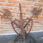 04536_1.jpg Scudo decorativo in ferro con leonessa e armi incrociate in rilievo