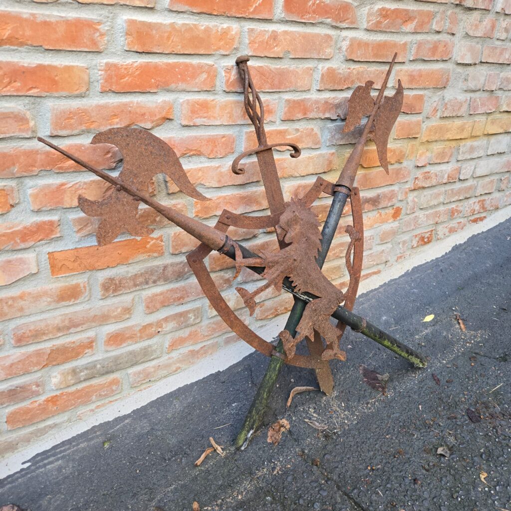 Scudo decorativo in ferro con leonessa e armi incrociate in rilievo