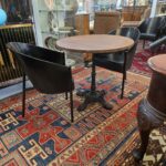 Tavolino da bar con base in ghisa lavorata e piano rotondo in legno massello tinto noce