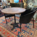 Tavolino da bar con base in ghisa lavorata e piano rotondo in legno massello tinto noce