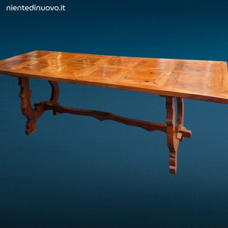 Tavolo in legno con piano intarsiato a formelle e struttura robusta