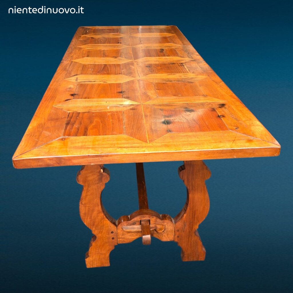 Tavolo in legno con piano intarsiato a formelle e struttura robusta