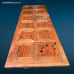 Tavolo in legno con piano intarsiato a formelle e struttura robusta