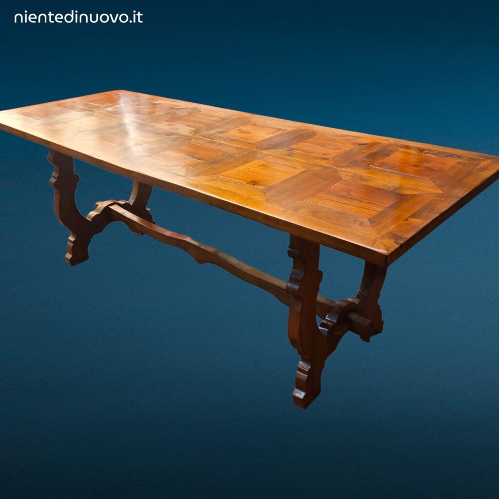 Tavolo in legno con piano intarsiato a formelle e struttura robusta