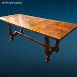 Tavolo in legno con piano intarsiato a formelle e struttura robusta