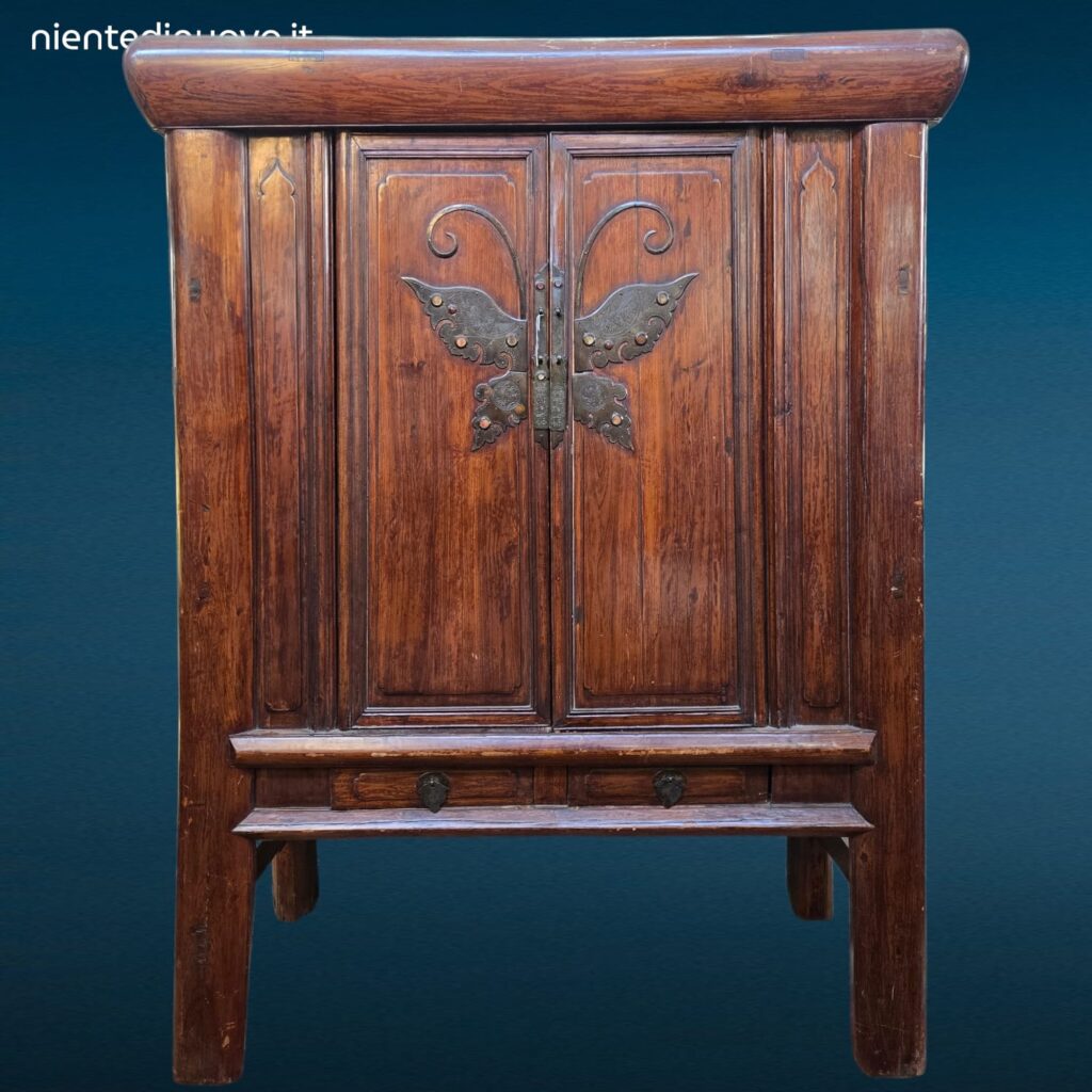 Armadio stipo cinese dinastia Qing in olmo con grande farfalla metallica sulle ante