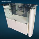 Banco cassa artigianale da negozio con teca in vetro illuminata e vano inferiore con serratura