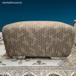 Pouff imbottito in tessuto con piedini in acciaio lucido dal design moderno