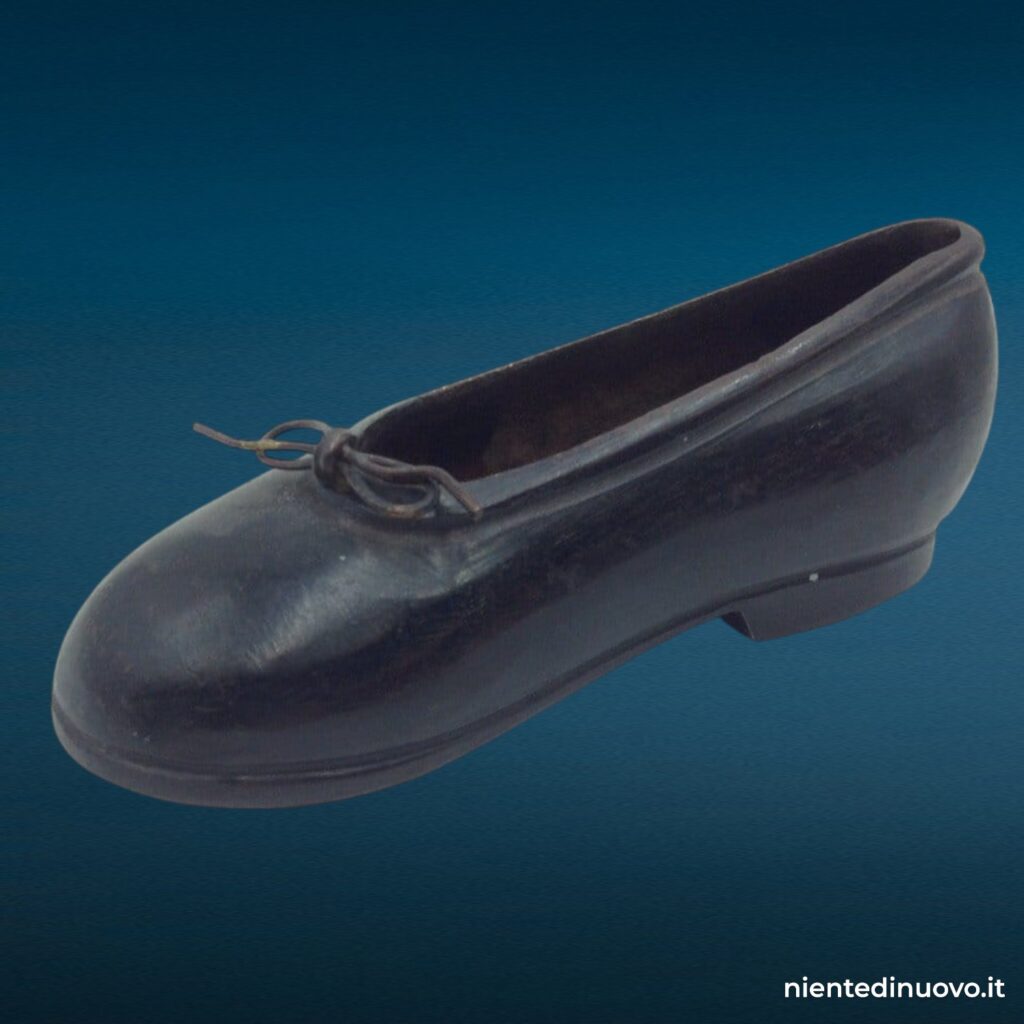 Scarpina soprammobile in ferro brunito a forma di scarpa da bambina con laccetto metallico, fermacarte vintage anni Trenta