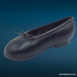 Scarpina soprammobile in ferro brunito a forma di scarpa da bambina con laccetto metallico, fermacarte vintage anni Trenta