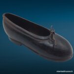 Scarpina soprammobile in ferro brunito a forma di scarpa da bambina con laccetto metallico, fermacarte vintage anni Trenta