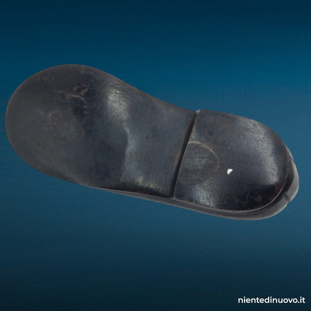 Scarpina soprammobile in ferro brunito a forma di scarpa da bambina con laccetto metallico, fermacarte vintage anni Trenta